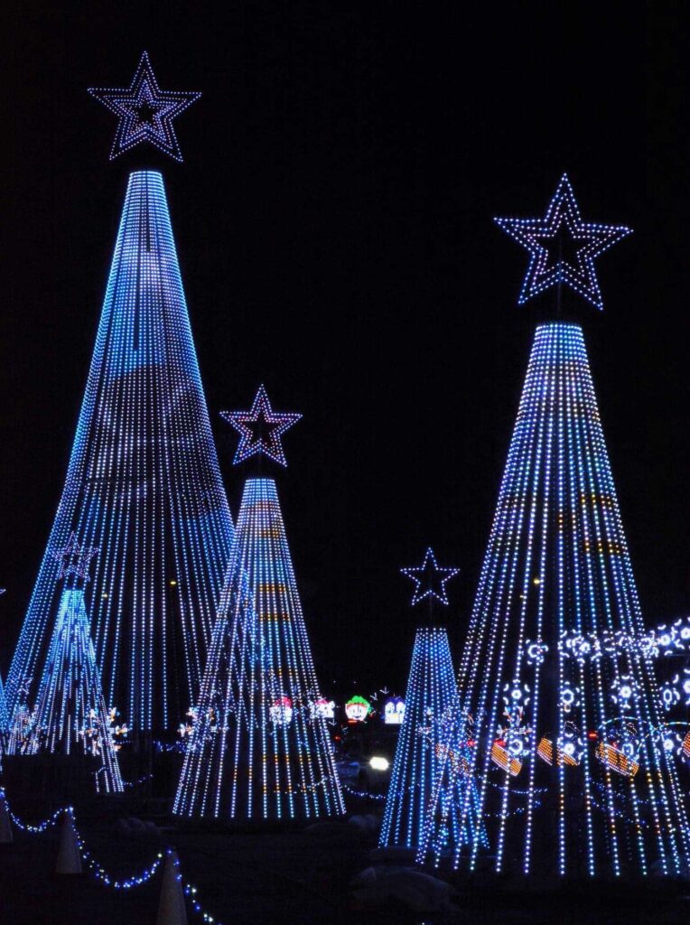 Holiday lights in the shape of a tree in white. The glowing shape of a star sits on top of the tree.