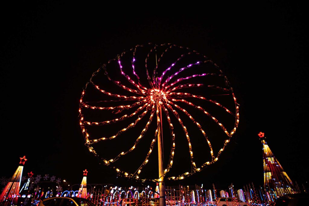Spinning wheel of lights that resemble a ferris wheel.